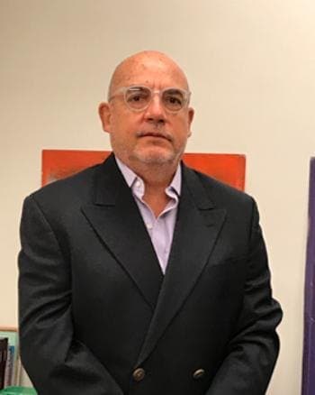 Agustín Ignacio Costa Paz, de traje oscuro y anteojos, en la oficina