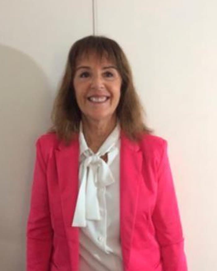 Magdalena Costa Paz, de blazer fucsia y camisa blanca, en la oficina